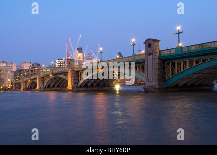 Southwark Bridge im Zentrum von London am frühen Abend mit den Straßenlaternen, reflektiert in den Fluss von der South Bank betrachten Stockfoto