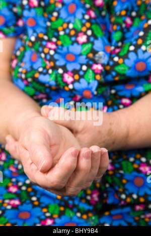 Händen der bettelnden Frau im bunten Kleid Stockfoto