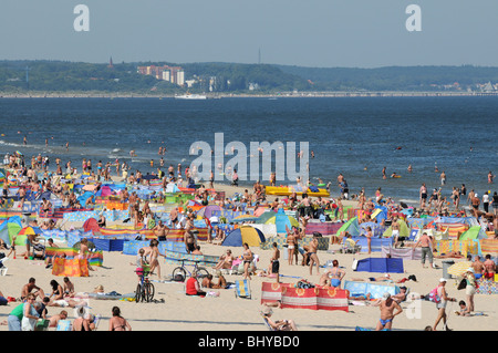Voller Touristen Ostseestrand in Swinoujscie, Polen. Deutsch Ahlbeck im Hintergrund gesehen. Stockfoto