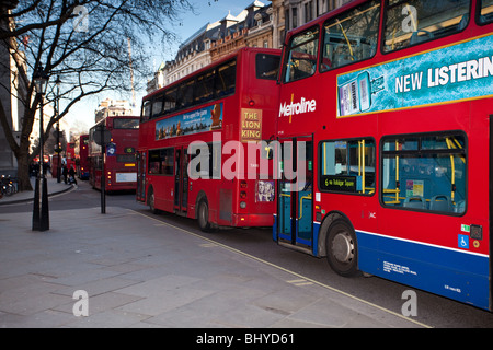 Das Bild zeigt eine Reihe von Red London doppelte Decker Busse Schlange, um Trafalgar Square in London zu durchqueren. Stockfoto