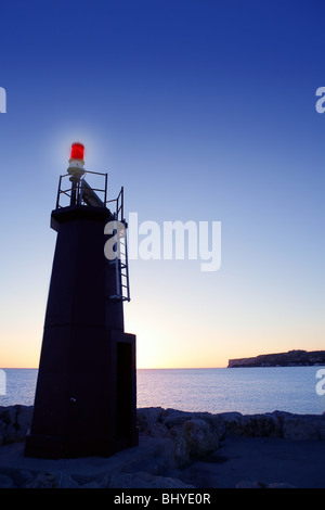 Blauer Himmel und roten Leuchtturm Glühen am Sonnenuntergang Meer Stockfoto