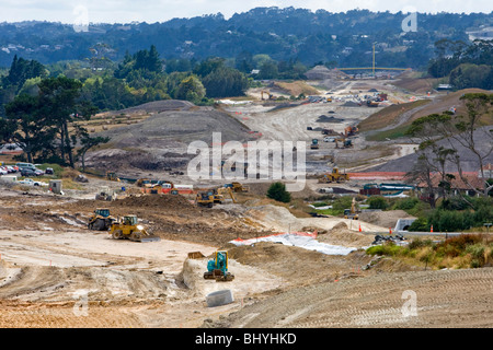 Baustelle in einem ländlichen Gebiet mit schweren Maschinen, die tagsüber auf Straßen- und Landbebauung arbeiten. Stockfoto