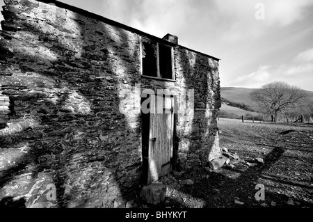 Unheimliche walisischen Scheune mit Schatten eines Baumes in schwarz / weiß Stockfoto