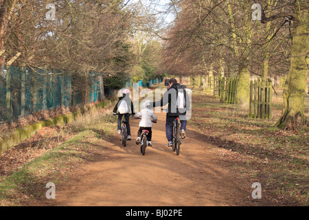 Ein Vater legt eine beruhigende Hand auf sein Kind auf einen Familienausflug Radfahren in Bushy Park, Hampton, UK. Stockfoto