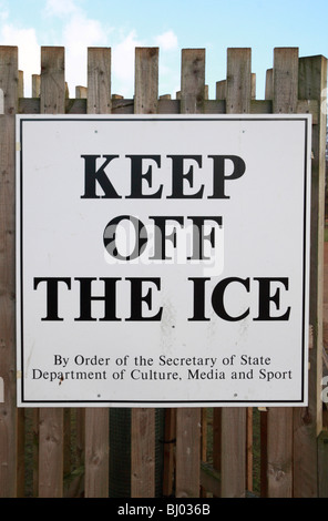 Ein Schild Warnung Besucher Bushy Park, Hampton, Middx über die Gefahren des Gehens auf dem Eis bedeckt Teich. Stockfoto