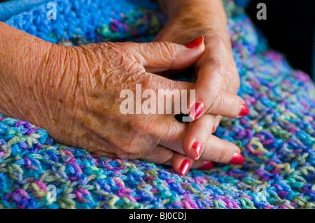 Womans Altern Hände ruhen auf gestrickte Decke. Stockfoto