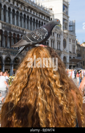 Markusplatz (Piazza San Marco) weibliche Touristen mit Taube auf den Kopf. Venedig Italien HOMER SYKES Stockfoto