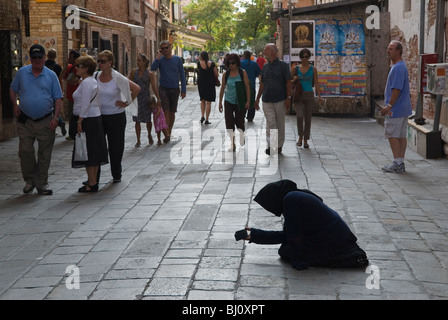 Flehen Sie Venedig Italien An. Paniert professionelle gefälschte Bettler Armut junge Roma-Frau, die als alte Italienerin gekleidet ist, die in Armut ist Venedig Italien. Bettelt von wohlhabenden Touristen-Gruppen. 2009 2000er Jahre HOMER SYKES Stockfoto