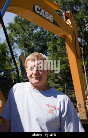 Operator steht vor Case Bagger. Stockfoto