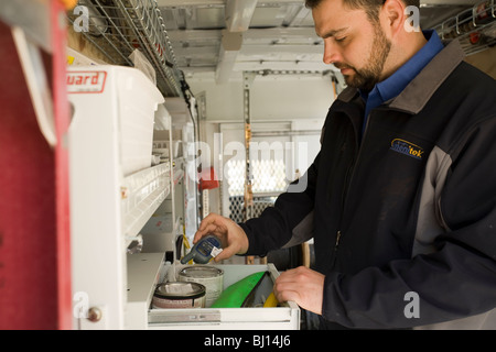 Techniker arbeitet innerhalb des van, die benötigte Ausrüstung zu home-Entertainment-Systeme installieren trägt. Stockfoto