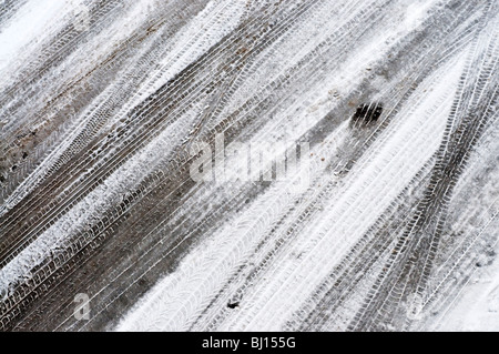 Schmelzende Auto-Spuren im Schnee bedeckt Straße - Frankreich. Stockfoto