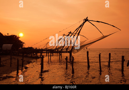 Indien, Kerala, Kochi, Fort Cochin, Strandpromenade, Chinesische Fischernetze bei Sonnenuntergang Stockfoto