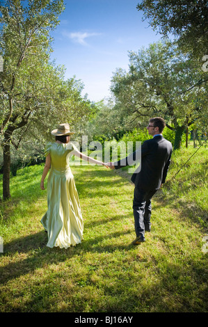 Braut und Bräutigam im Garten Hand in Hand gehen Stockfoto