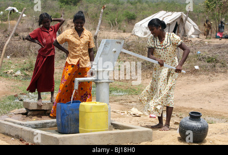 Frauen, die Wäsche an eine Wasserpumpe in einem Tierheim für Binnenvertriebene, Vakaneri, Sri Lanka Stockfoto