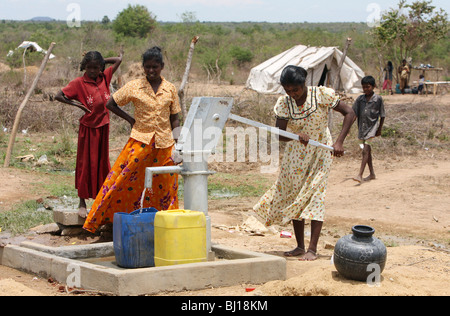 Frauen, die Wäsche an eine Wasserpumpe in einem Tierheim für Binnenvertriebene, Vakaneri, Sri Lanka Stockfoto