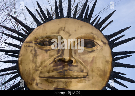 Sun Skulptur Nahaufnahme. Eine schöne und große Skulptur von der Sonne aus Messing mit Blick auf den Kinderspielplatz Stockfoto