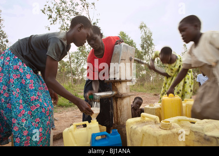 Mädchen ziehen Wasser aus einem Brunnen in Amuria, Uganda, Ostafrika. Stockfoto