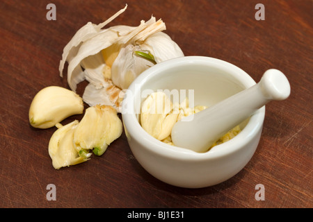 Knoblauch bereit für Maischen in einem Mörser und Stößel Stockfoto