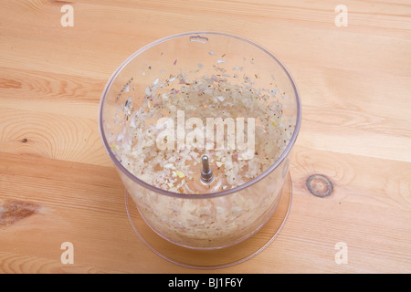 Fein gehackte Lebensmittel verarbeitet Schalotten in Plastikbehälter auf hölzerne Arbeitsfläche. Stockfoto