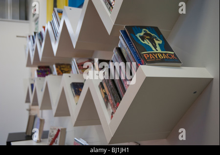 Bücher über schrägen Bücherregale in Hamworthy Bibliothek, Poole. Stockfoto