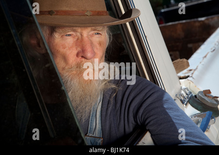 Ein älterer Mann mit einem weißen Bart ein Pickup-Truck zu fahren und starrte aus dem Fenster Stockfoto