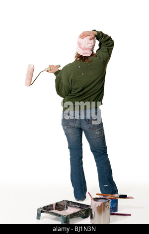 Eine Frau betrachtet wie sie bereitet sich auf eine Wand malen. Stockfoto