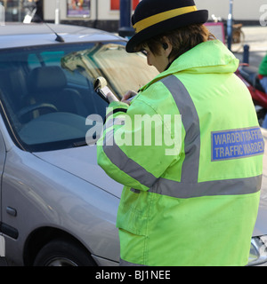 Eine weibliche Traffic Warden schreiben oder die Ausstellung eines Parkschein, Aberystwyth Wales UK Stockfoto