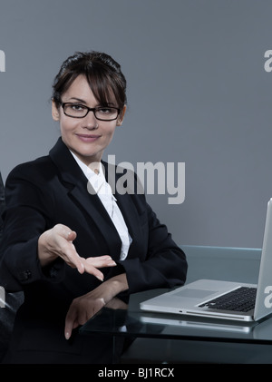 schöne fröhliche kaukasischen Geschäftsfrau sitzen am Schreibtisch auf isolierte Hintergrund Stockfoto