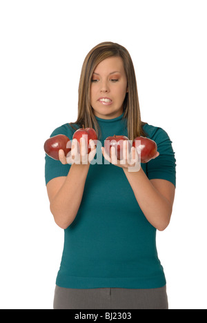 Eine junge Frau hält 4 Äpfel, "Äpfel mit Äpfeln vergleichen". Stockfoto