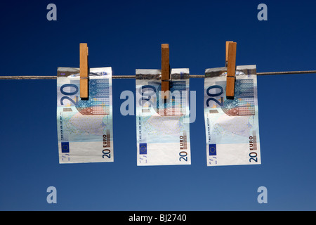 drei 20 Euro-Banknoten an eine Wäscheleine mit blauem Himmel hängen Stockfoto