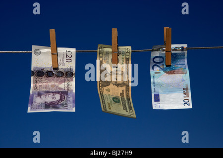 zwanzig Pfund-Dollar-Euro-Banknoten an eine Wäscheleine mit blauem Himmel hängen Stockfoto