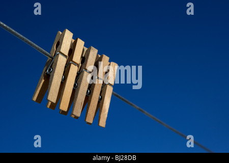 fünf Clothespegs hautnah hängt eine Wäscheleine mit blauem Himmel Stockfoto