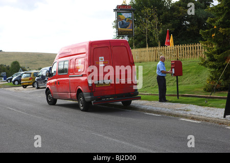 Der Post-Mann auf seine tägliche Runde Entleerung eines Sammelboxen in einer abgelegenen Stadtteil von Hampshire. Stockfoto