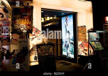 Gehalt-Mann-Betrieb ein Handy vor einem japanischen bar (Izakaya), Tokyo-Shinjuku. Stockfoto