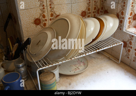 Zeile der angeschlagenen gebrochene Platten in einem schmutzigen heruntergekommen Küche in Südamerika Stockfoto