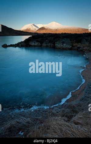 Dickes Eis am Ufer eines kleinen Strand am man Na h-Achlaise an Rannoch Moor. Stockfoto