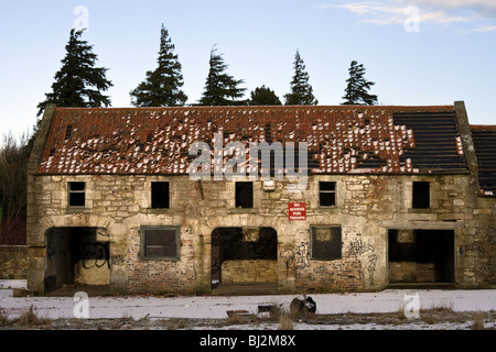 Ein verlassenes Gebäude an einem Wintertag. Ein Schild an der Wand liest "keinen Zugang für die Truppen" Stockfoto