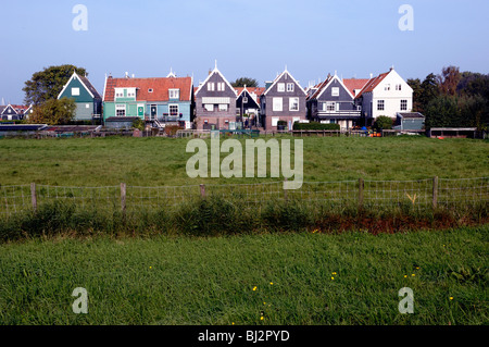 Häuser mit roten Ziegeldächern am Rande einer Wiese in der 17. Jahrhundert Fischerei Dorf Marken in Nord-Holland. Stockfoto