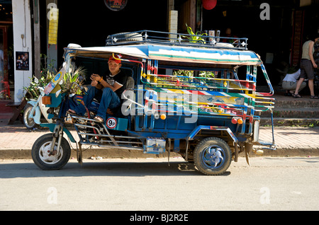 Ein Tuk Tuk Fahrer ruht auf sein Taxi in Luang Prabang Laos Stockfoto