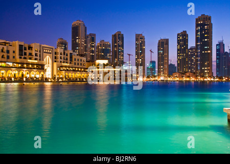 Dämmerung Blick auf Downtown Dubai und der Burj Dubai Lake mit dem Souk al Bahar auf der linken und Hochhäuser im Hintergrund. Stockfoto