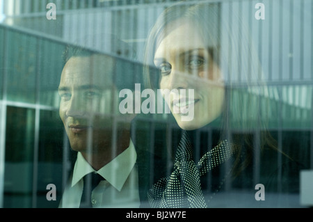 Geschäftsmann und Frau schaut aus Fenster Stockfoto