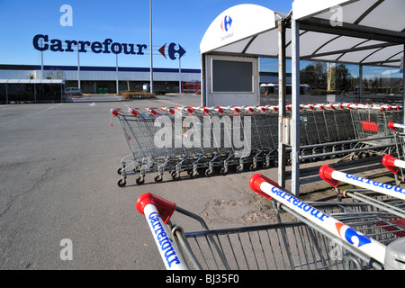 Reihen von abgestellten Einkaufswagen, ausgestattet mit einem Münz-Mechanismus im Supermarkt Carrefour in Belgien Stockfoto