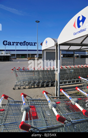 Reihen von abgestellten Einkaufswagen, ausgestattet mit einem Münz-Mechanismus im Supermarkt Carrefour in Belgien Stockfoto