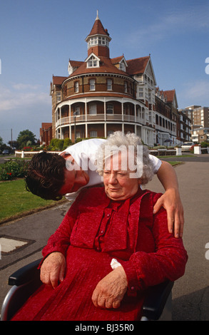 Ein Pfleger aus eine ältere Völker Wohn-Hause Kurven hinunter zu sprechen, eine alte Dame, die für ihren täglichen Spaziergang ergangen ist Stockfoto