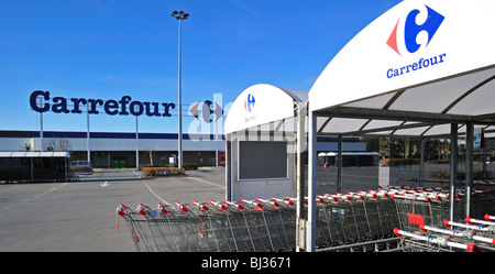 Reihen von abgestellten Einkaufswagen, ausgestattet mit einem Münz-Mechanismus im Supermarkt Carrefour in Belgien Stockfoto