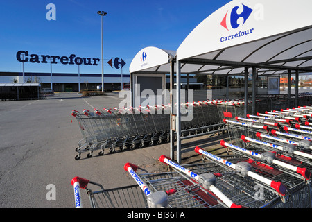 Reihen von abgestellten Einkaufswagen, ausgestattet mit einem Münz-Mechanismus im Supermarkt Carrefour in Belgien Stockfoto