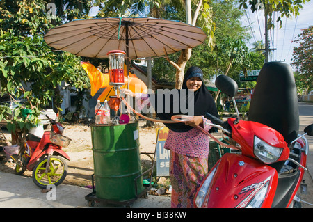 Muslimische Frau einen Roller tanken Tankstelle am Klong Nin Beach, Ko Lanta oder Koh Lanta Island, Krabi, Thailand, Asien Stockfoto