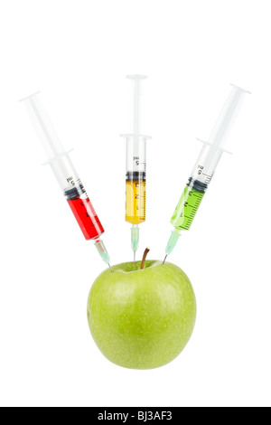 Ein grüner Apfel mit drei Spritzen mit Farbe Flüssigkeiten, isoliert auf weißem Hintergrund injiziert werden. Geringe Schärfentiefe Stockfoto