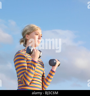 Junge Frau mit Hanteln Stockfoto