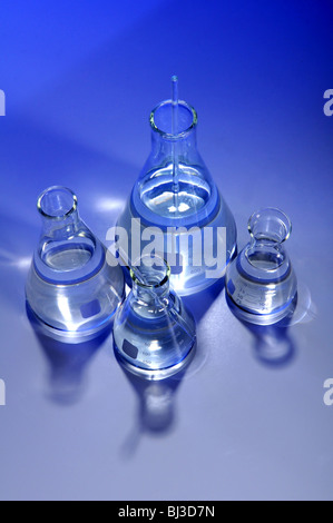 Verschiedene Flaschen mit Flüssigkeit durchdrungen mit blauem Licht Stockfoto